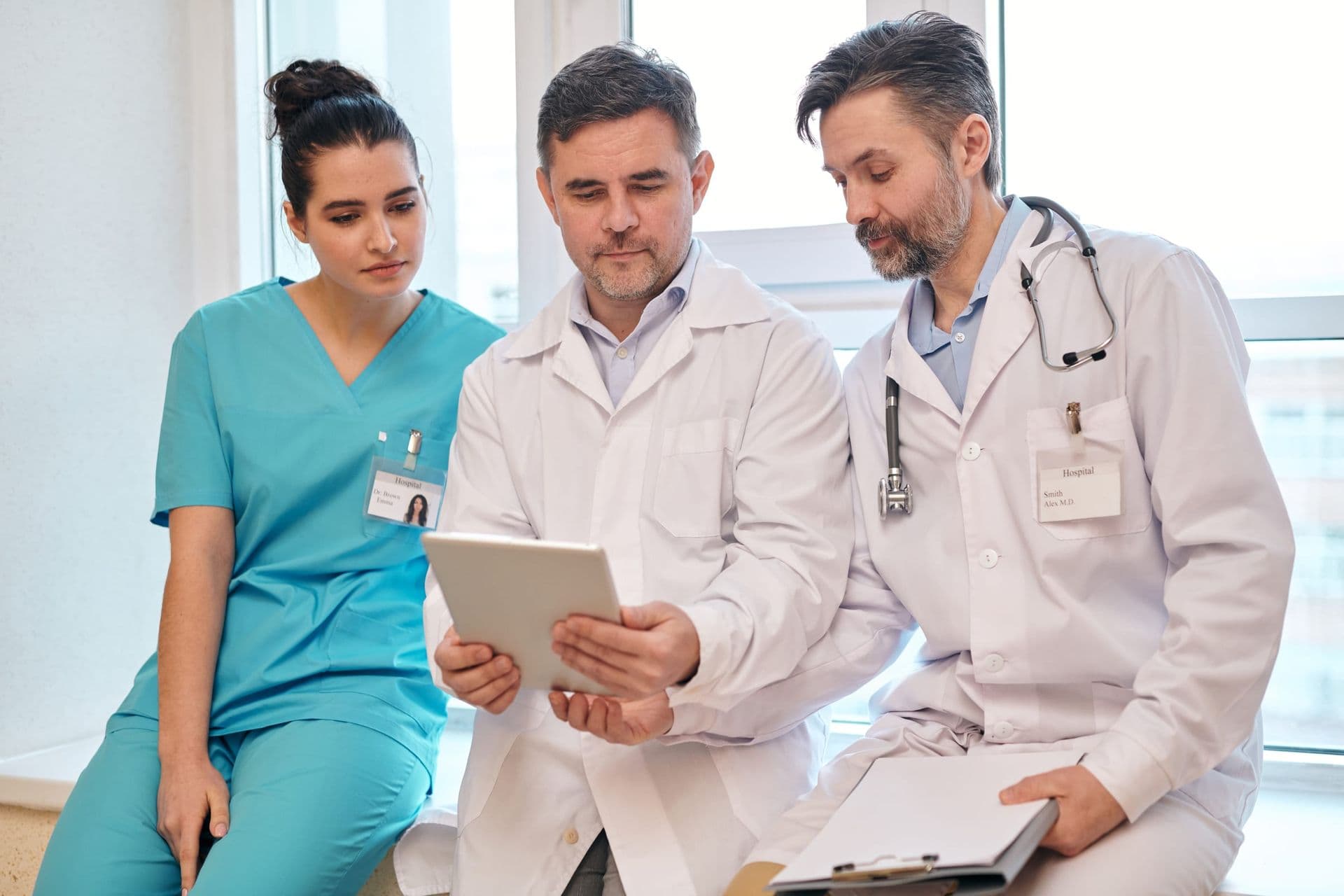 Three clinicians reviewing information on a tablet together